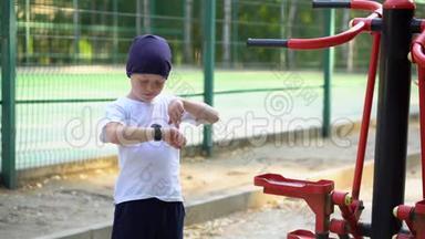 街上一个男孩在公共健身器材上看手表